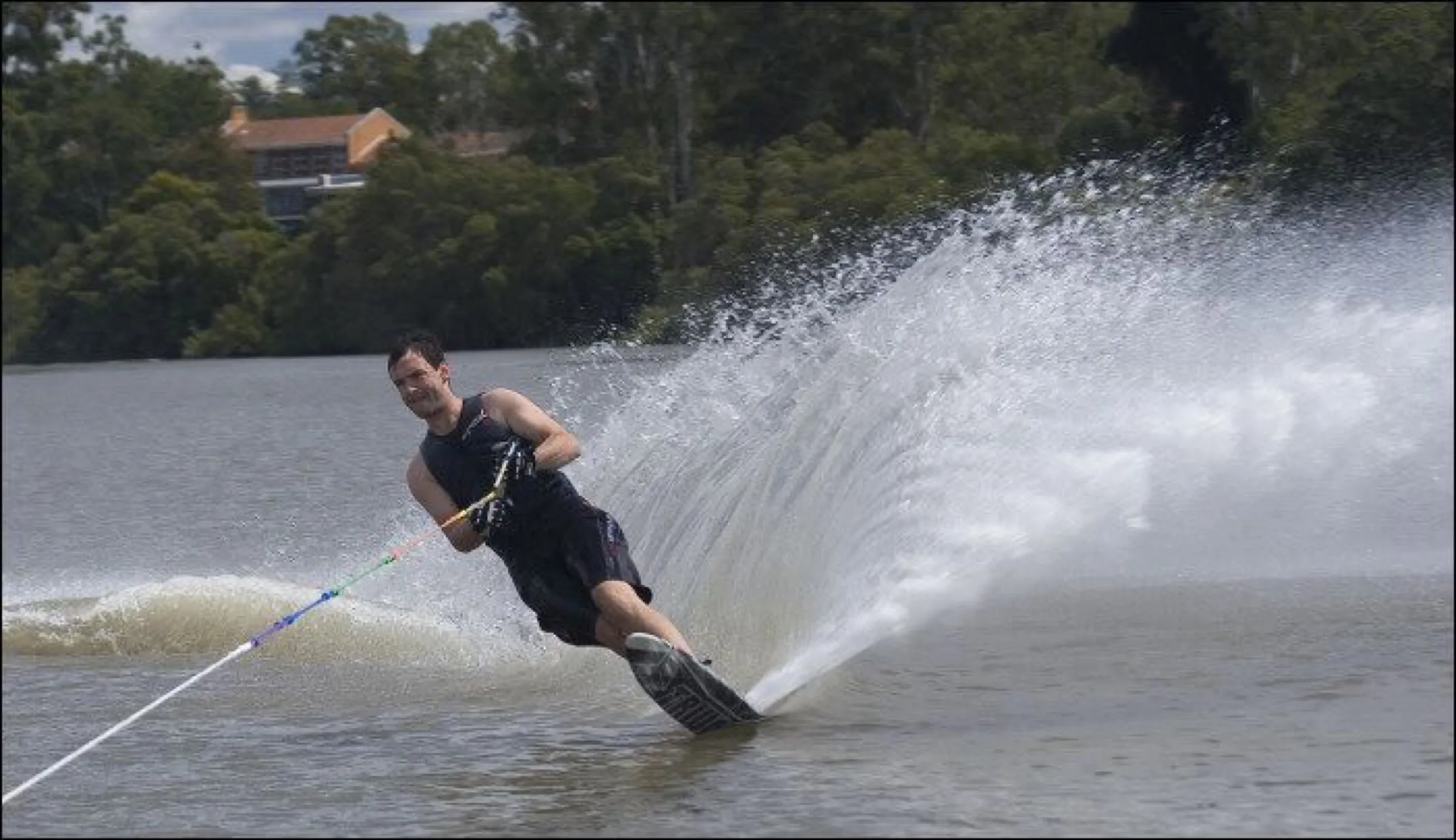 Andrew carving a slalom turn, throwing a wall of spray